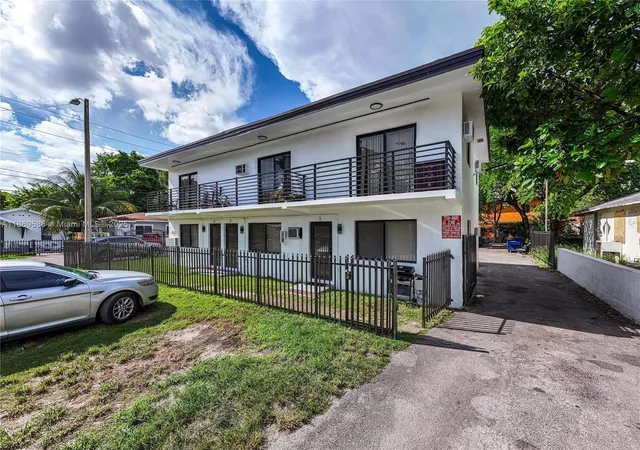 a view of a house with a small yard and flower plants