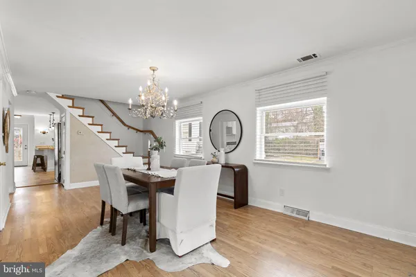 a view of a dining room with furniture a chandelier and wooden floor