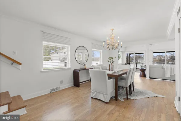 a view of a dining room with furniture a chandelier and wooden floor