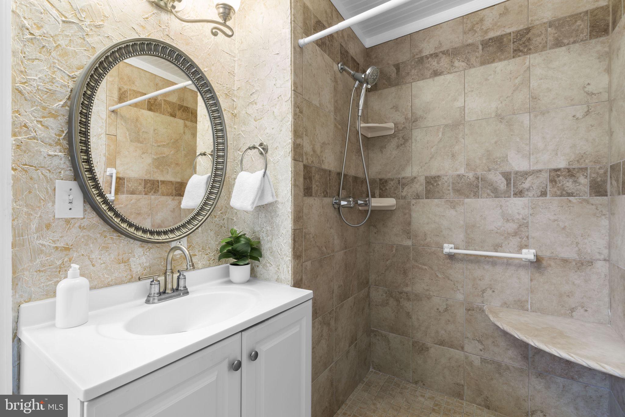 452 Carvel Beach Road Carvel Beach, MD 21226 - Photo 22 of 71 a bathroom with a sink a mirror a vanity and a shower