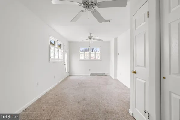 an empty room with a window and wooden floor