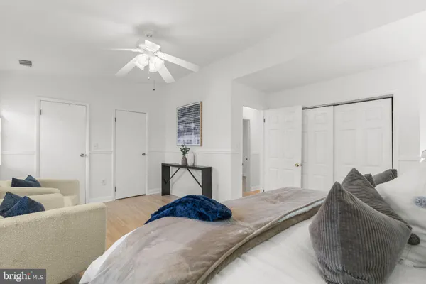 a living room with furniture large window and wooden floor