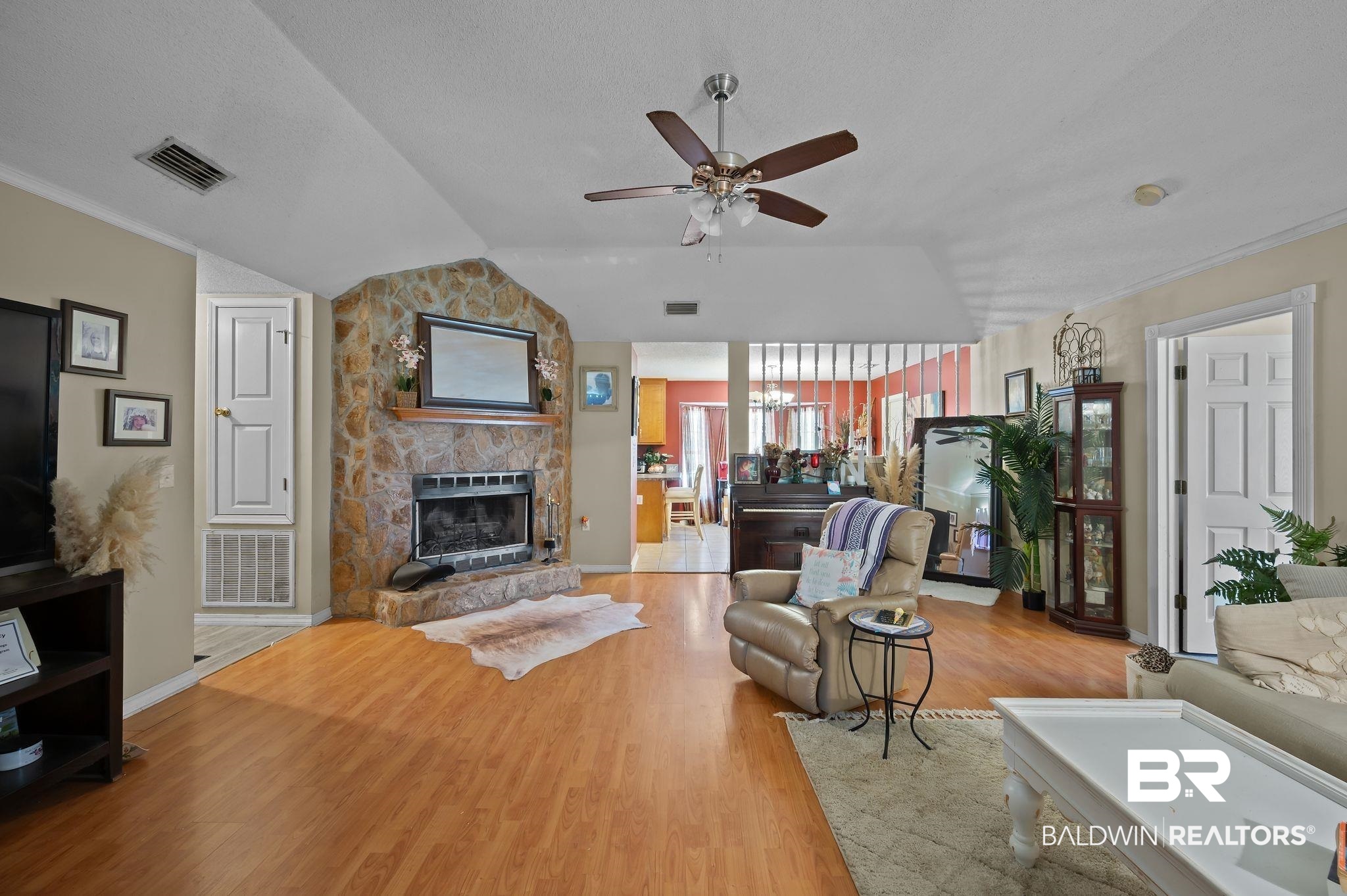 52923 Ammons Road Perdido, AL 36562 - Photo 8 of 35 Living area featuring a ceiling fan, a fireplace, wood finished floors, lofted ceiling, and ornamental molding