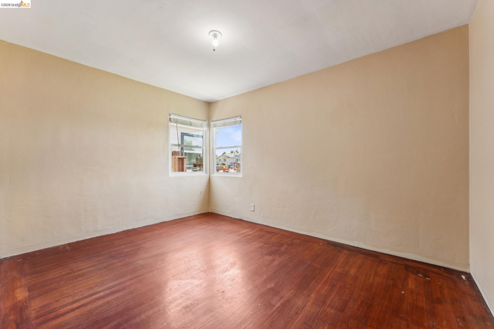 2879 Rheem Avenue Richmond, CA 94804 - Photo 27 of 45 Room featuring wood-finish flooring, neutral wall tones, and corner windows