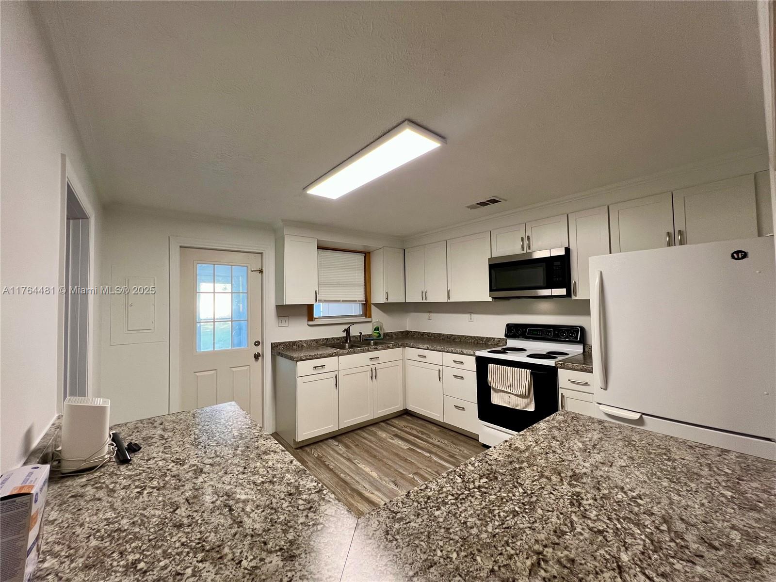 2985 Hilltop Road St. Augustine, FL 32086 - Photo 18 of 26 a kitchen with stainless steel appliances kitchen island granite countertop a refrigerator stove top oven and sink