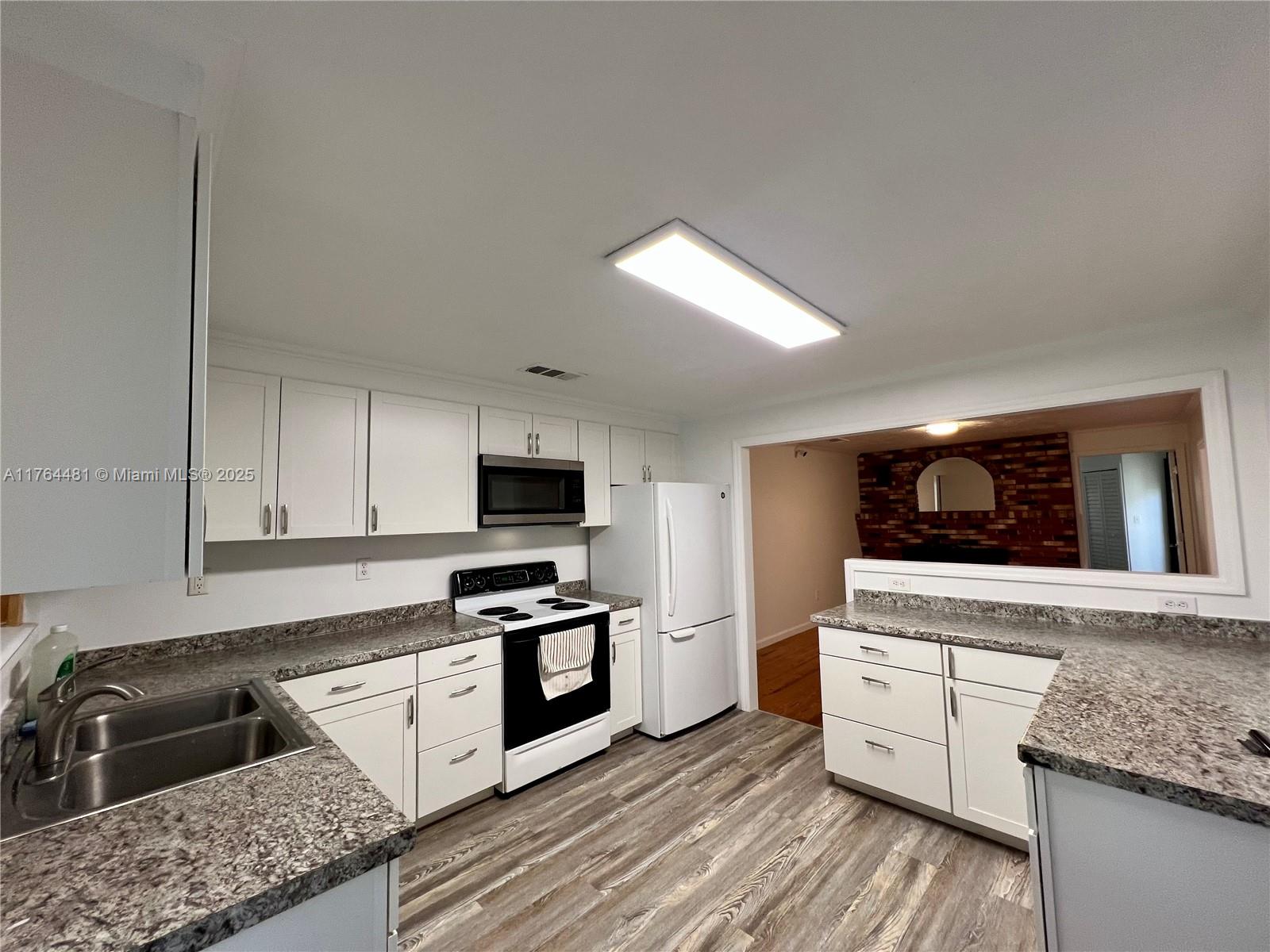 2985 Hilltop Road St. Augustine, FL 32086 - Photo 19 of 26 a kitchen with granite countertop a sink and a stove top oven
