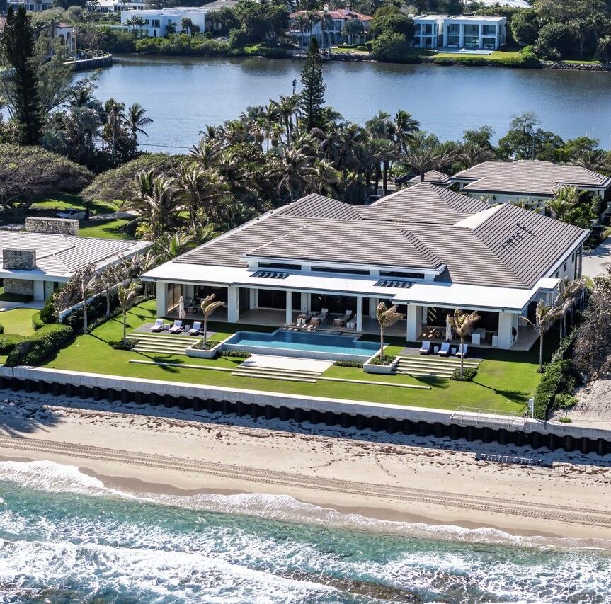 an aerial view of a house with a garden and lake view