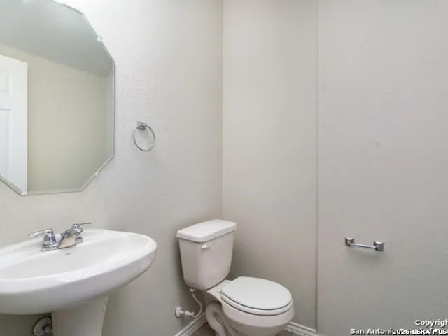 a bathroom with a sink a toilet and mirror