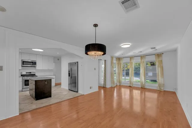 a kitchen with stainless steel appliances granite countertop a stove and a wooden floors