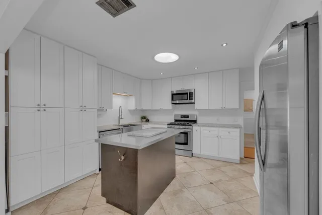 a kitchen with stainless steel appliances granite countertop a stove a refrigerator and a sink