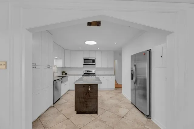 a kitchen with stainless steel appliances granite countertop a refrigerator and a sink