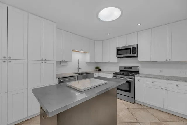 a kitchen with appliances a sink and cabinets