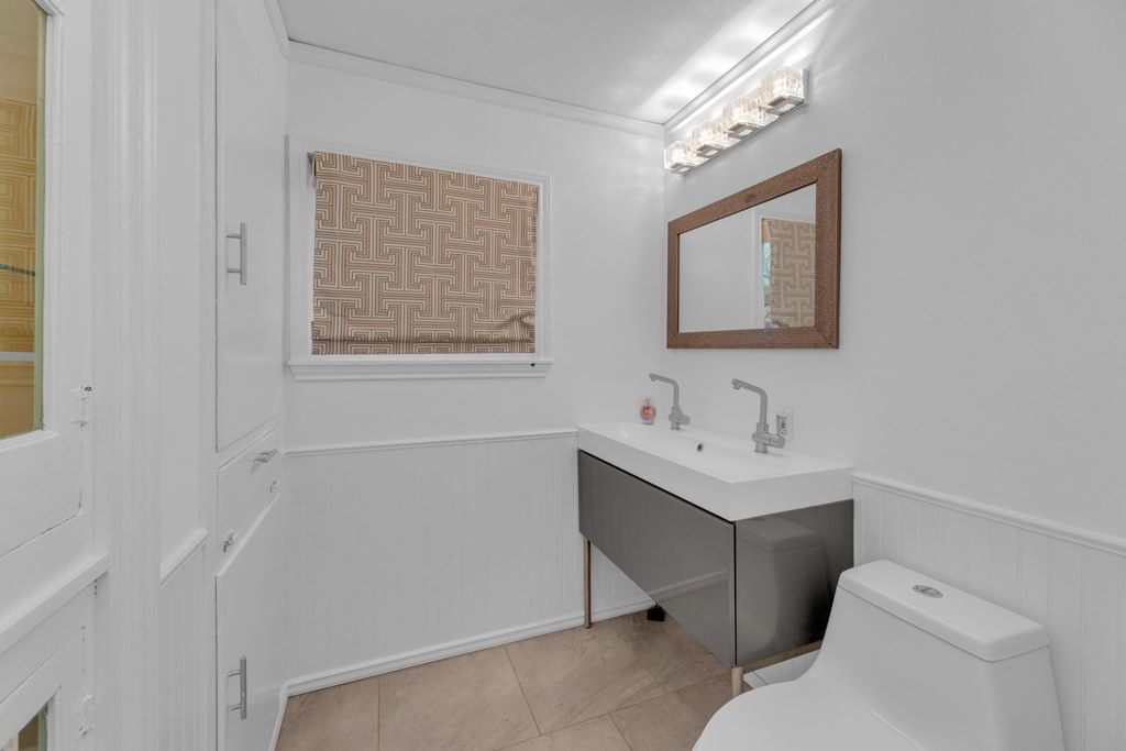 1224 Corona Drive Austin, TX 78723 - Photo 24 of 37 a bathroom with a toilet sink vanity and mirror