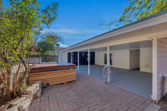 a backyard of a house with barbeque oven table and chairs