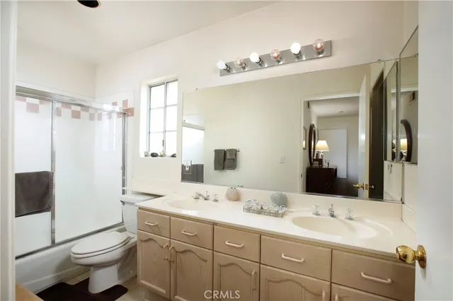 a bathroom with a double vanity sink toilet and shower