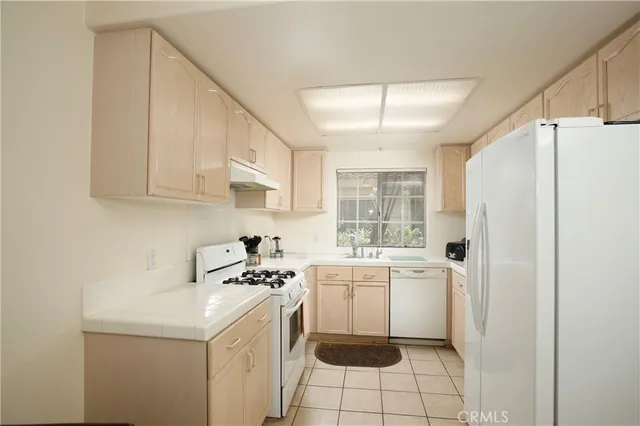 a kitchen with a sink a refrigerator and cabinets