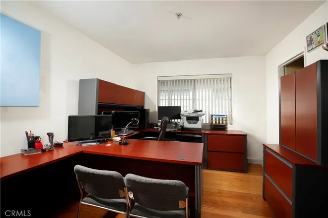 a work room with furniture a flat screen tv and a window