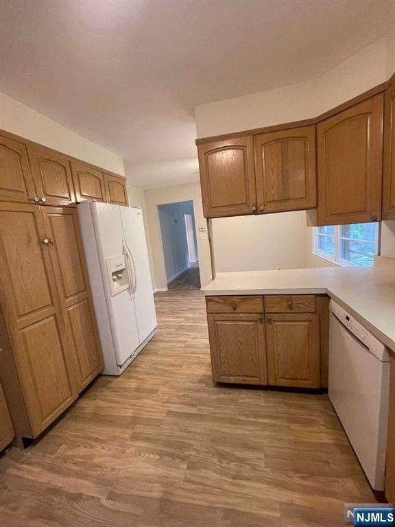 338 Queens Court Ridgewood, NJ 07450 - Photo 11 of 25 a kitchen with wooden cabinets and white appliances