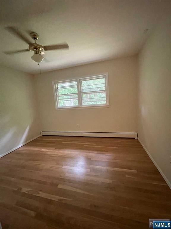 338 Queens Court Ridgewood, NJ 07450 - Photo 18 of 25 an empty room with wooden floor fan and windows