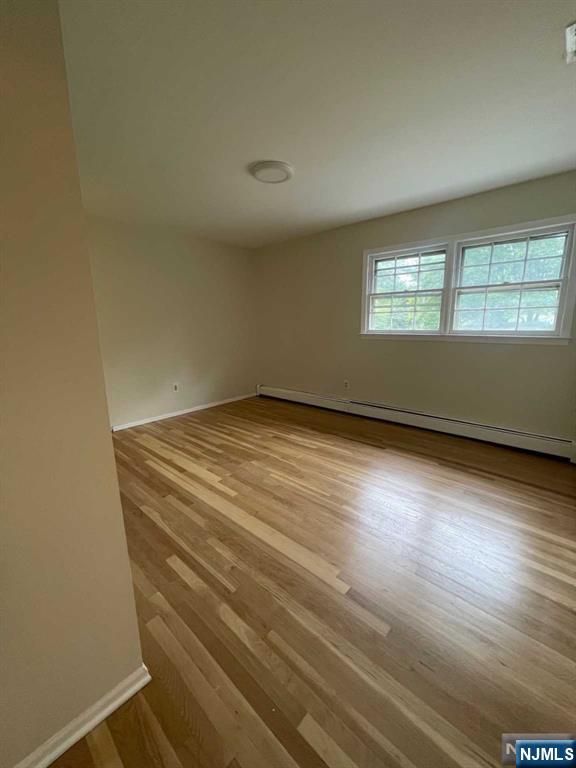 338 Queens Court Ridgewood, NJ 07450 - Photo 21 of 25 an empty room with wooden floor and windows