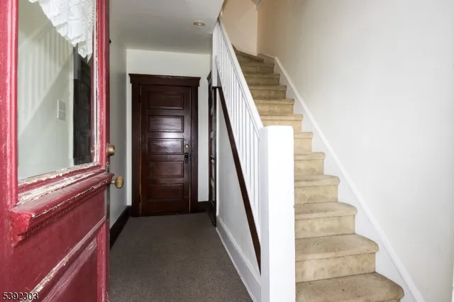 a view of staircase with railing and white walls