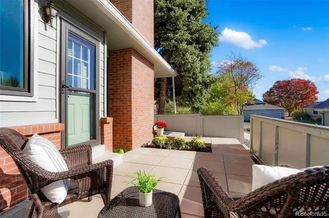 a view of a patio with couches table and chairs and potted plants