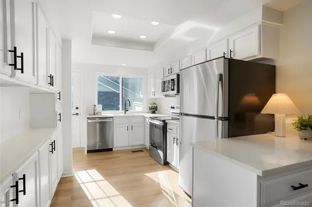 a kitchen with a sink refrigerator and microwave