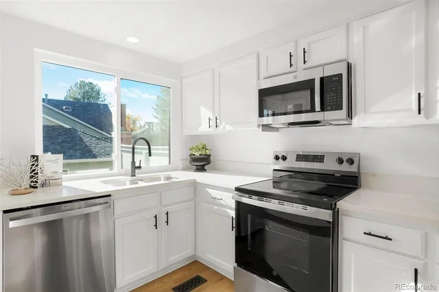 a kitchen with cabinets stainless steel appliances and a sink