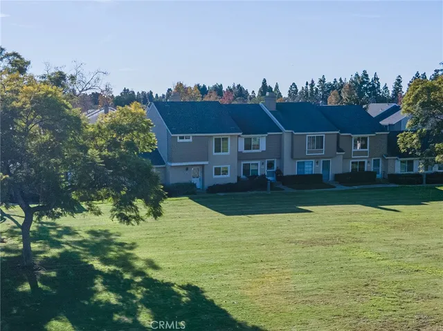 an aerial view of residential houses with yard and lake view