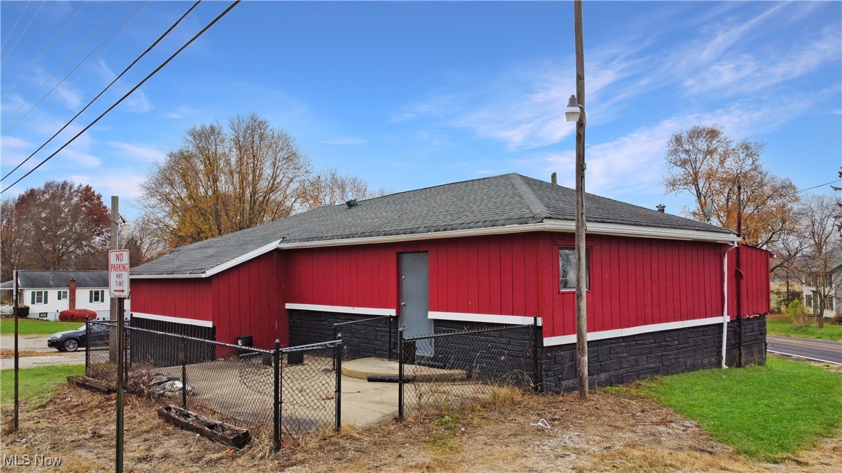 15580 Rittman Road Rittman, OH 44270 - Photo 1 of 11 View of side of home featuring a shingled roof and a gate