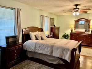 1515 Southwest 19th Terrace Okeechobee, FL 34974 - Photo 15 of 39 a bedroom with a bed and a chandelier