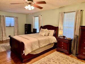 1515 Southwest 19th Terrace Okeechobee, FL 34974 - Photo 16 of 39 a bedroom with a bed and a chandelier