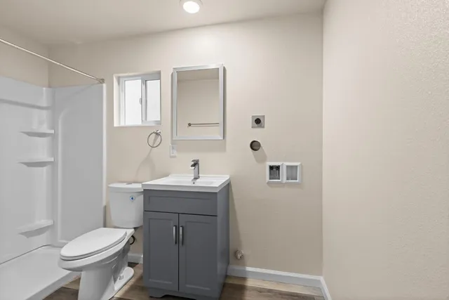 a bathroom with a sink a toilet and shower