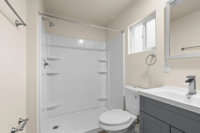 a bathroom with a sink a toilet and shower