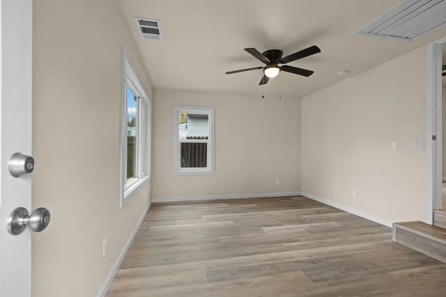 a view of a livingroom with a hardwood floor and a ceiling fan