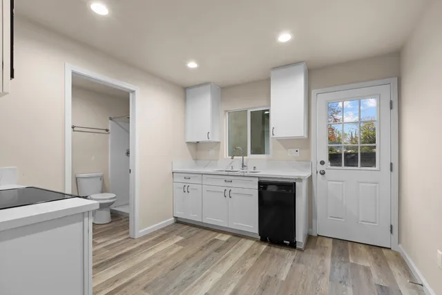 a kitchen with sink cabinets and wooden floor