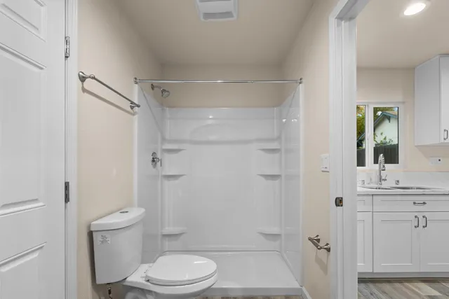 a bathroom with a toilet a sink and shower