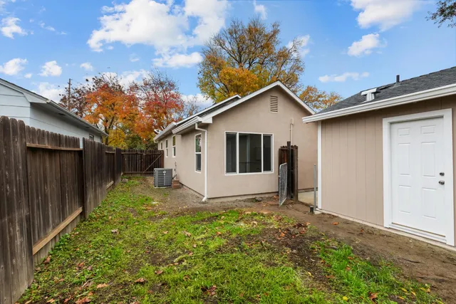 a white house that has tree in front of it