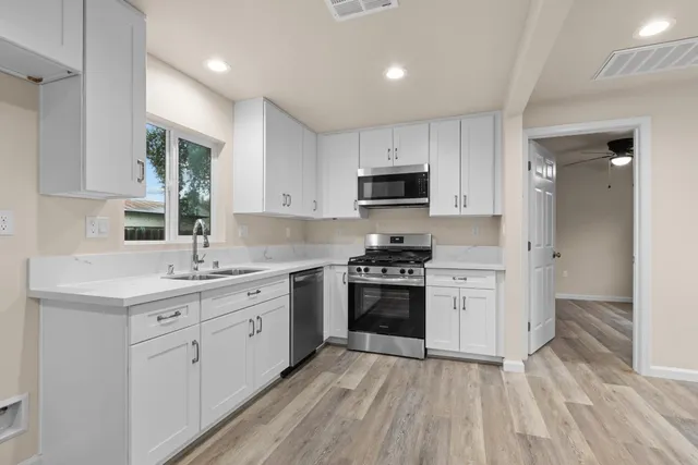 a kitchen with stainless steel appliances a sink stove and cabinets