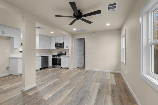 a view of a kitchen with a sink and dishwasher a refrigerator with wooden floor