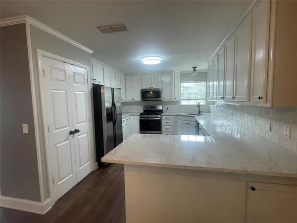 a kitchen with granite countertop a refrigerator and a sink