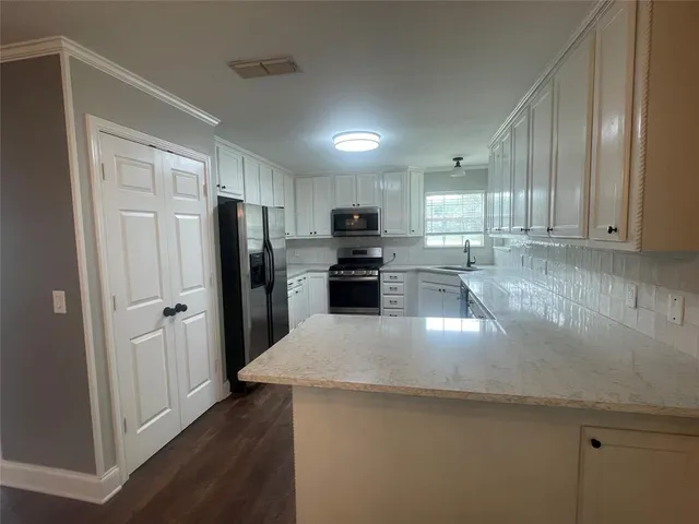 a kitchen with granite countertop a refrigerator and a sink