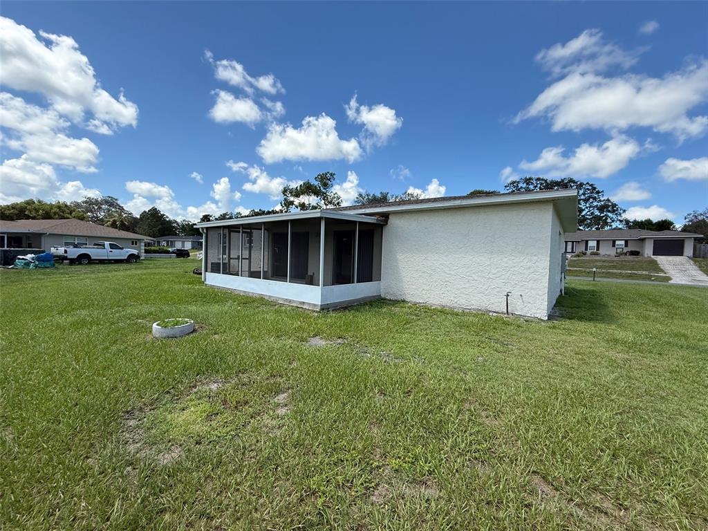 7319 Holiday Drive Spring Hill, FL 34606 - Photo 16 of 20 a view of a house with a backyard porch and sitting area