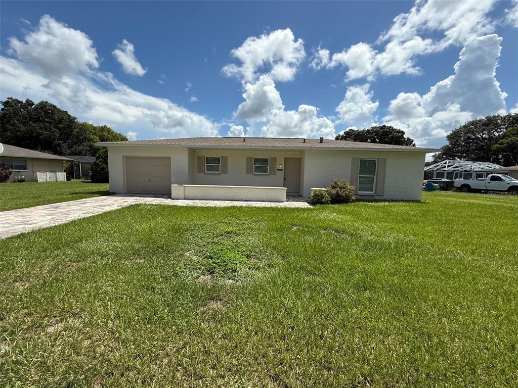 7319 Holiday Drive Spring Hill, FL 34606 - Photo 20 of 20 a view of a house with a yard and a garden