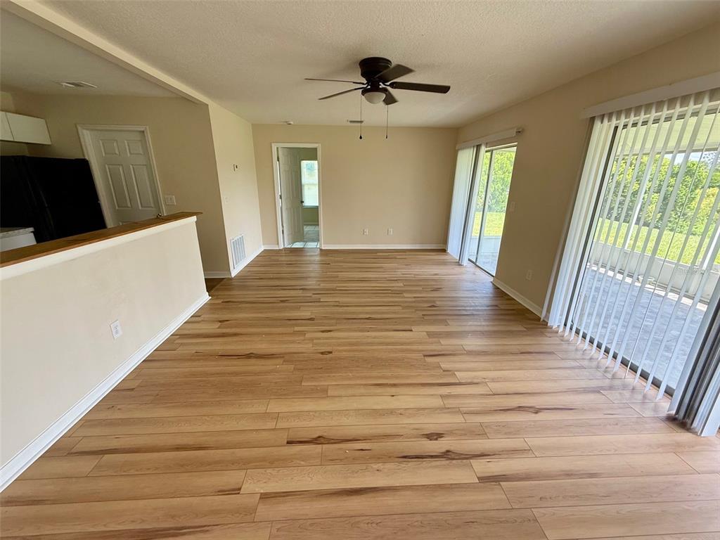7319 Holiday Drive Spring Hill, FL 34606 - Photo 2 of 20 a view of an empty room with wooden floor and a window