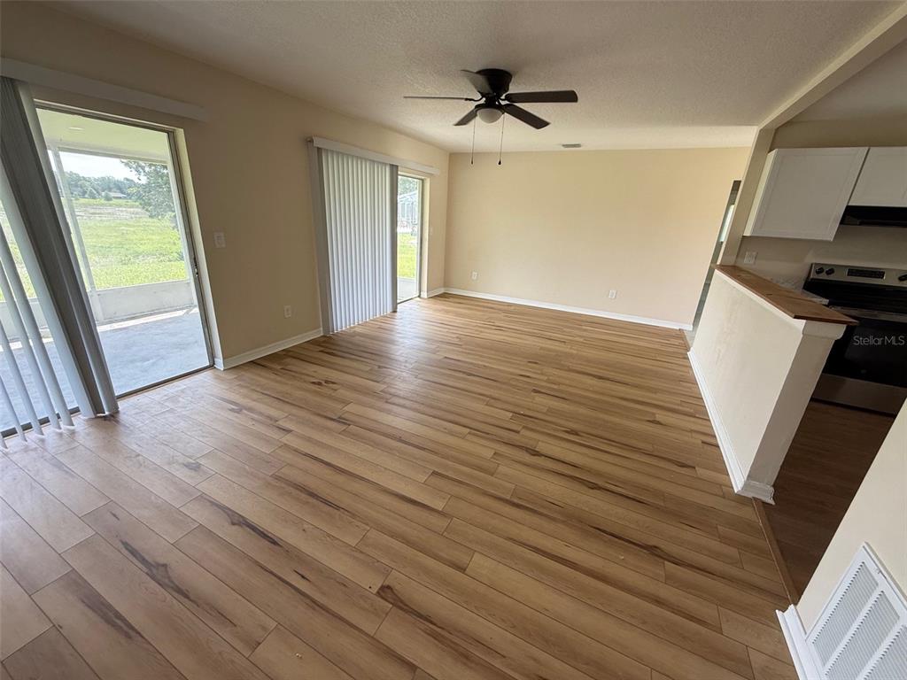 7319 Holiday Drive Spring Hill, FL 34606 - Photo 3 of 20 a view of a livingroom with wooden floor and a ceiling fan