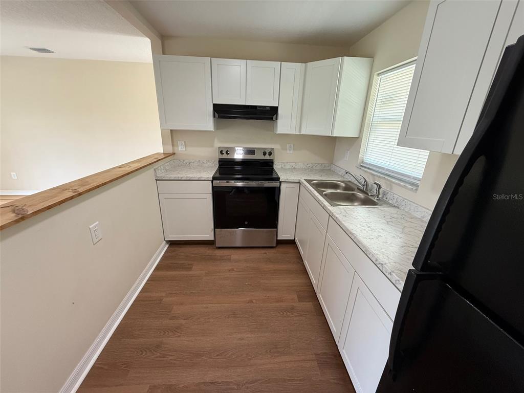 7319 Holiday Drive Spring Hill, FL 34606 - Photo 6 of 20 a kitchen with a stove a sink and a refrigerator