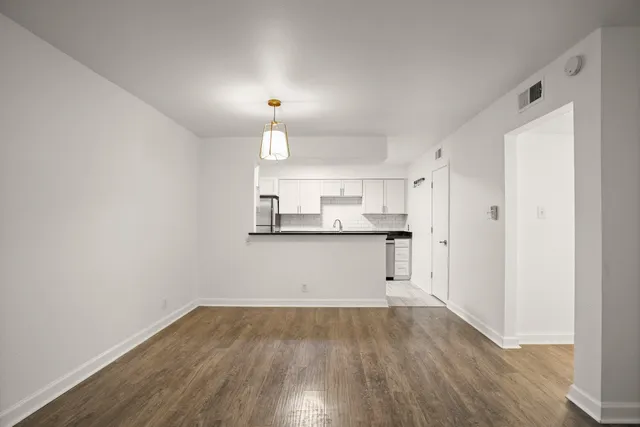 a view of a kitchen with wooden floor and electronic appliances