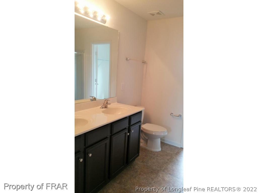 12 River Oak Street Spring Lake, NC 28390 - Photo 18 of 34 a bathroom with a toilet a sink and mirror