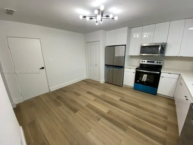 a kitchen with a refrigerator and a stove top oven